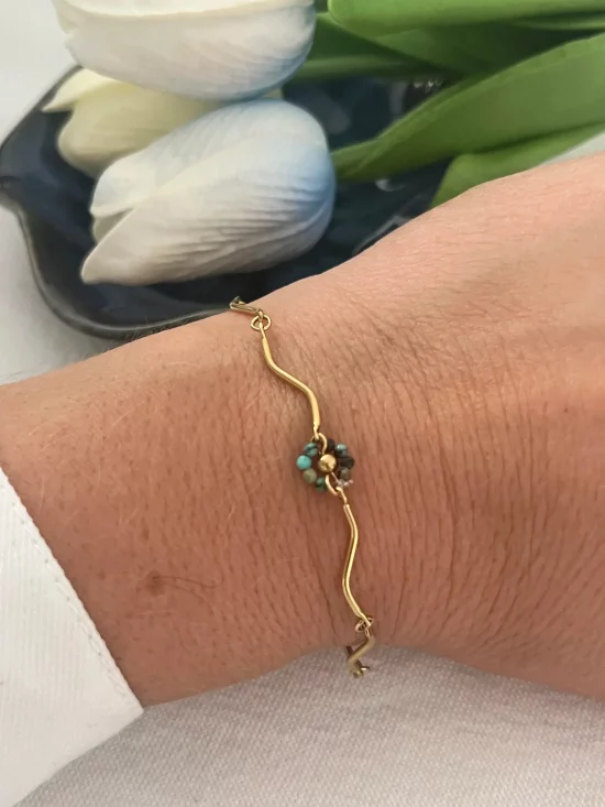 bracelet en acier inoxydable doré avec fleur en perle au centre nallia bijoux a aimargues